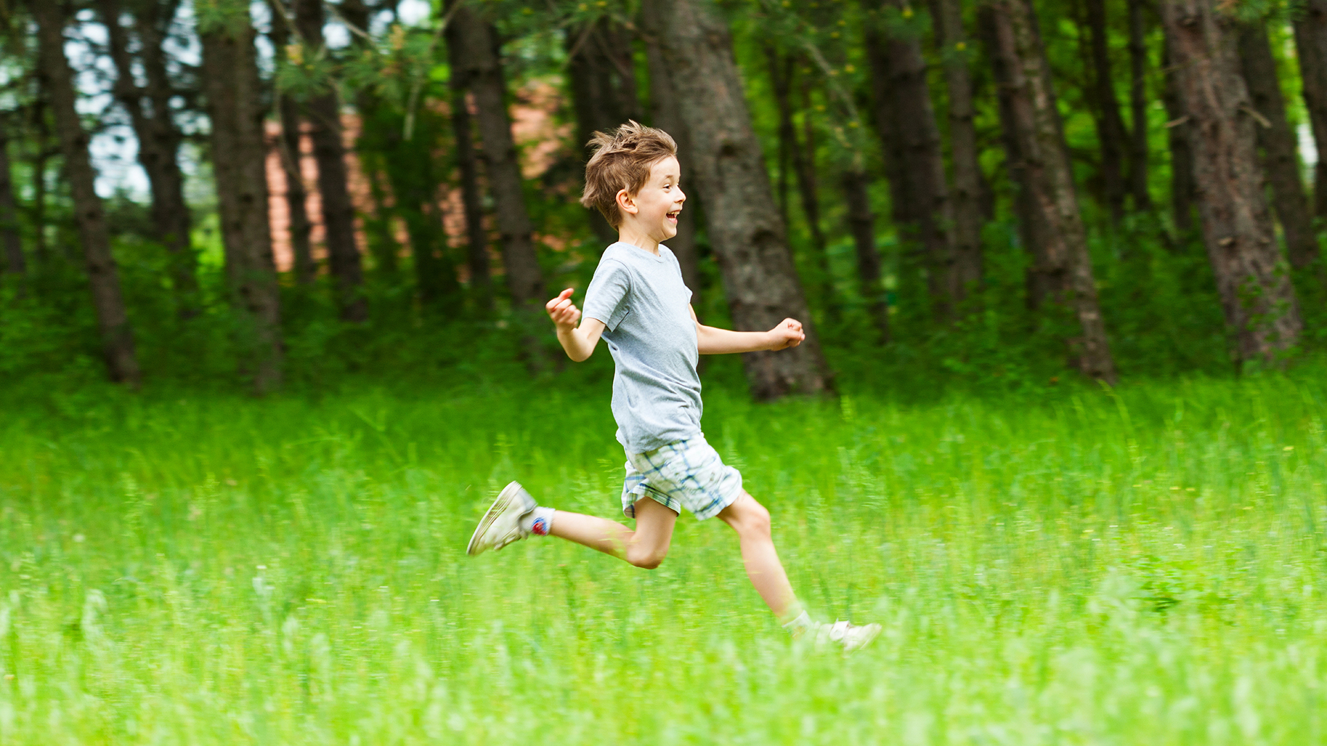 boy running in a field of grass