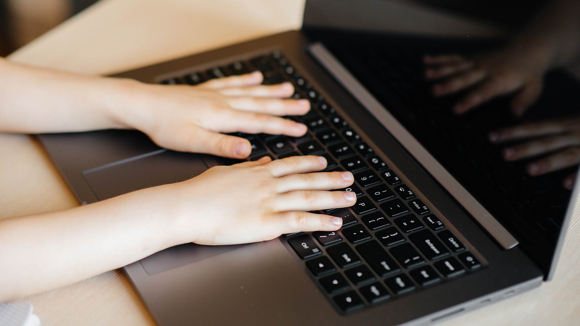 little hands on a laptop keyboard