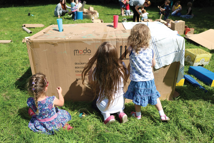 Kids playing on cardboard boxes