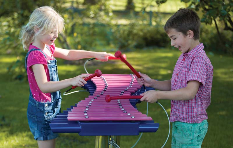 Kids playing on musical playground equipment