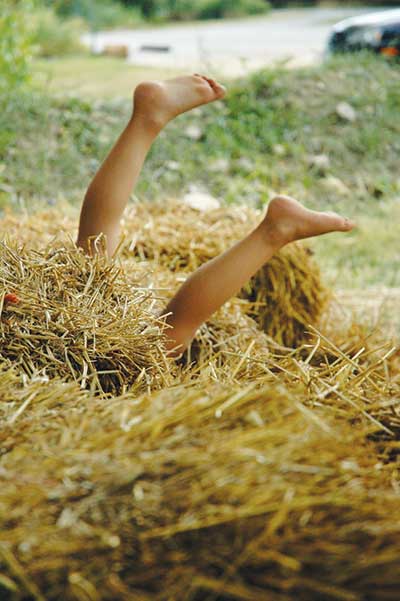 Child's legs sticking out of hay