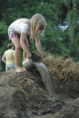 Girl pouring water out of a bucket