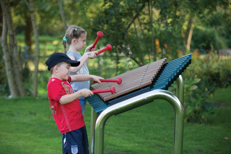 Kids playing on musical playground equipment