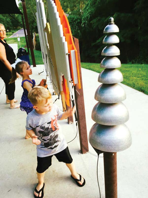 Kids playing on musical playground equipment