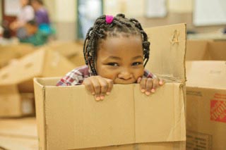 Girl playing in cardboard box