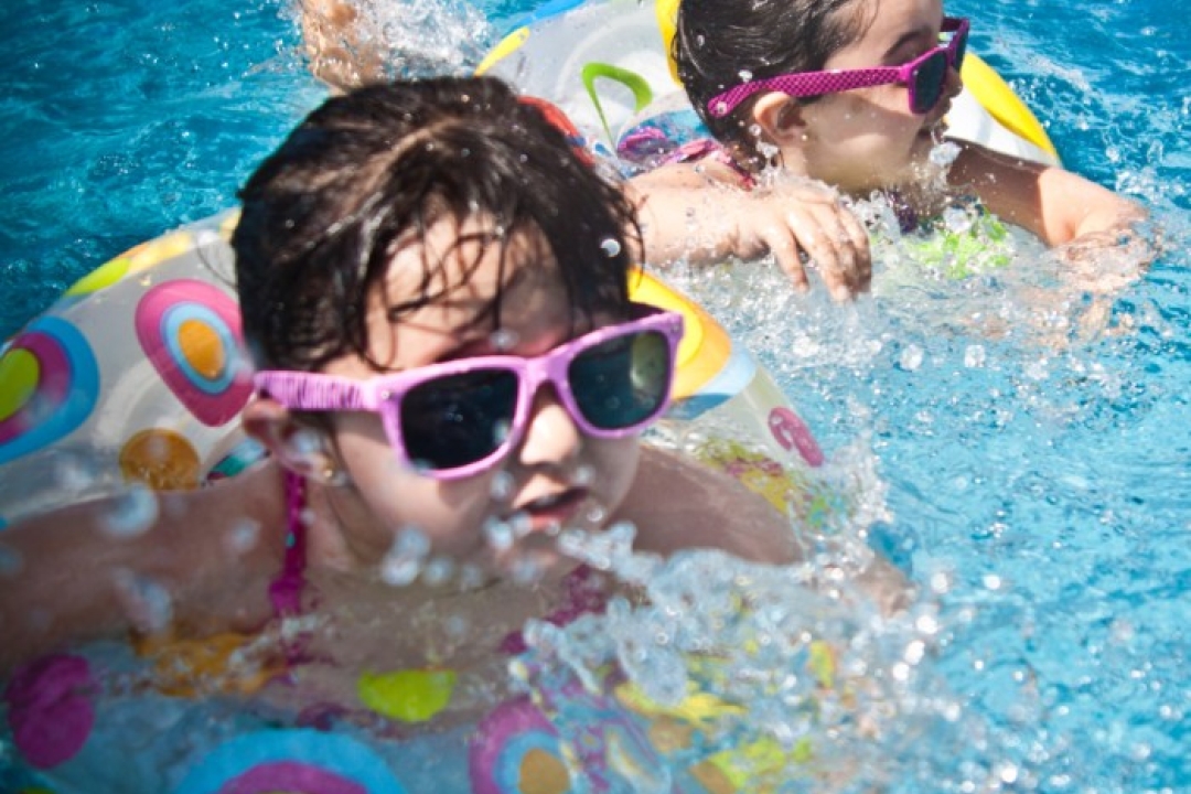 Two young girls in a swimming pool.