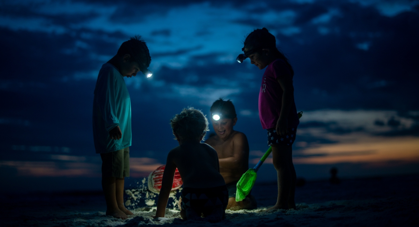 Kids playing on a beach at night