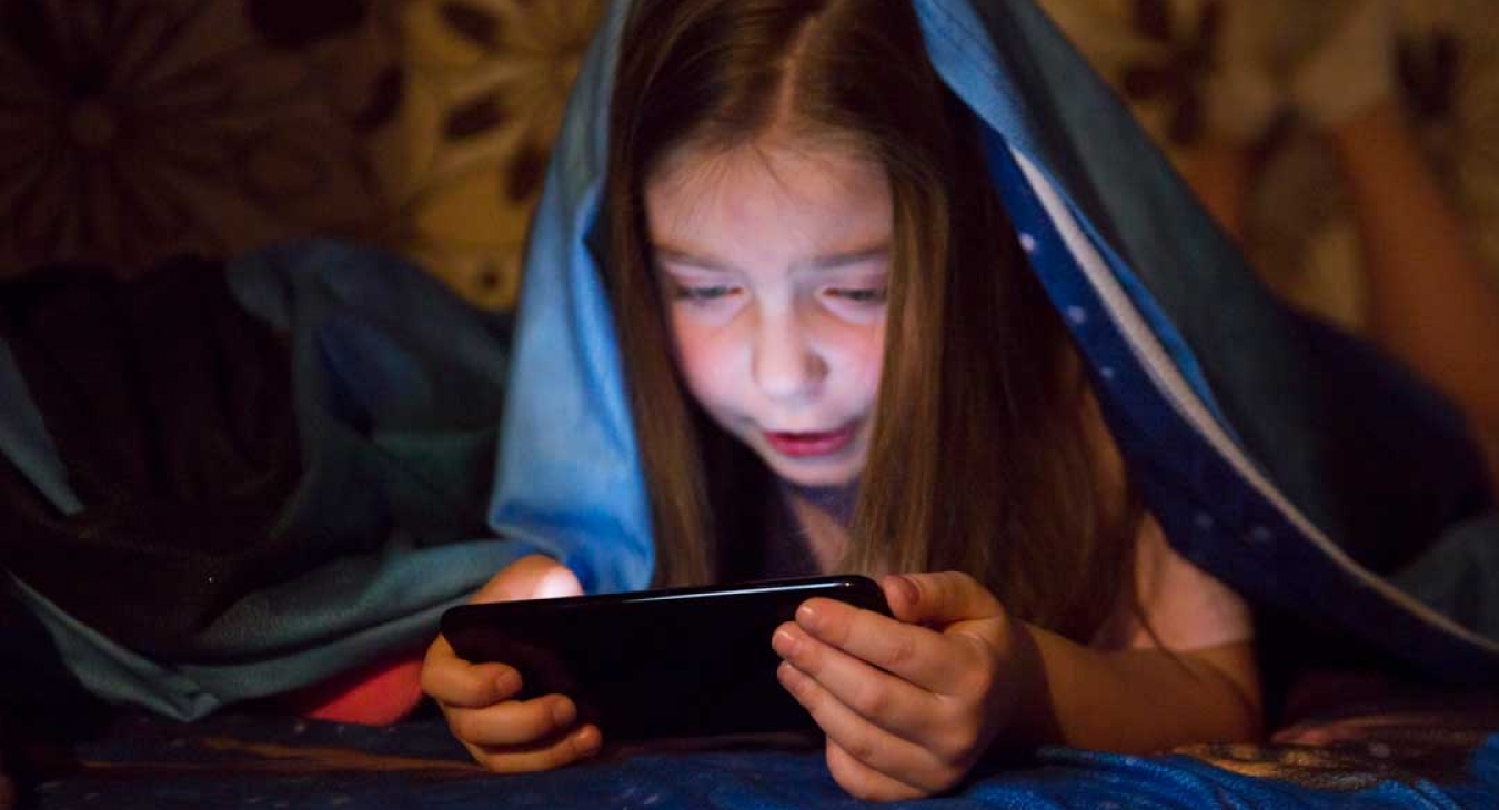 girl playing smartphone game in a dark room