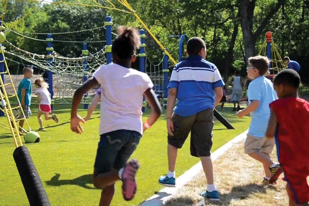 group of kids running to a newly completed playground
