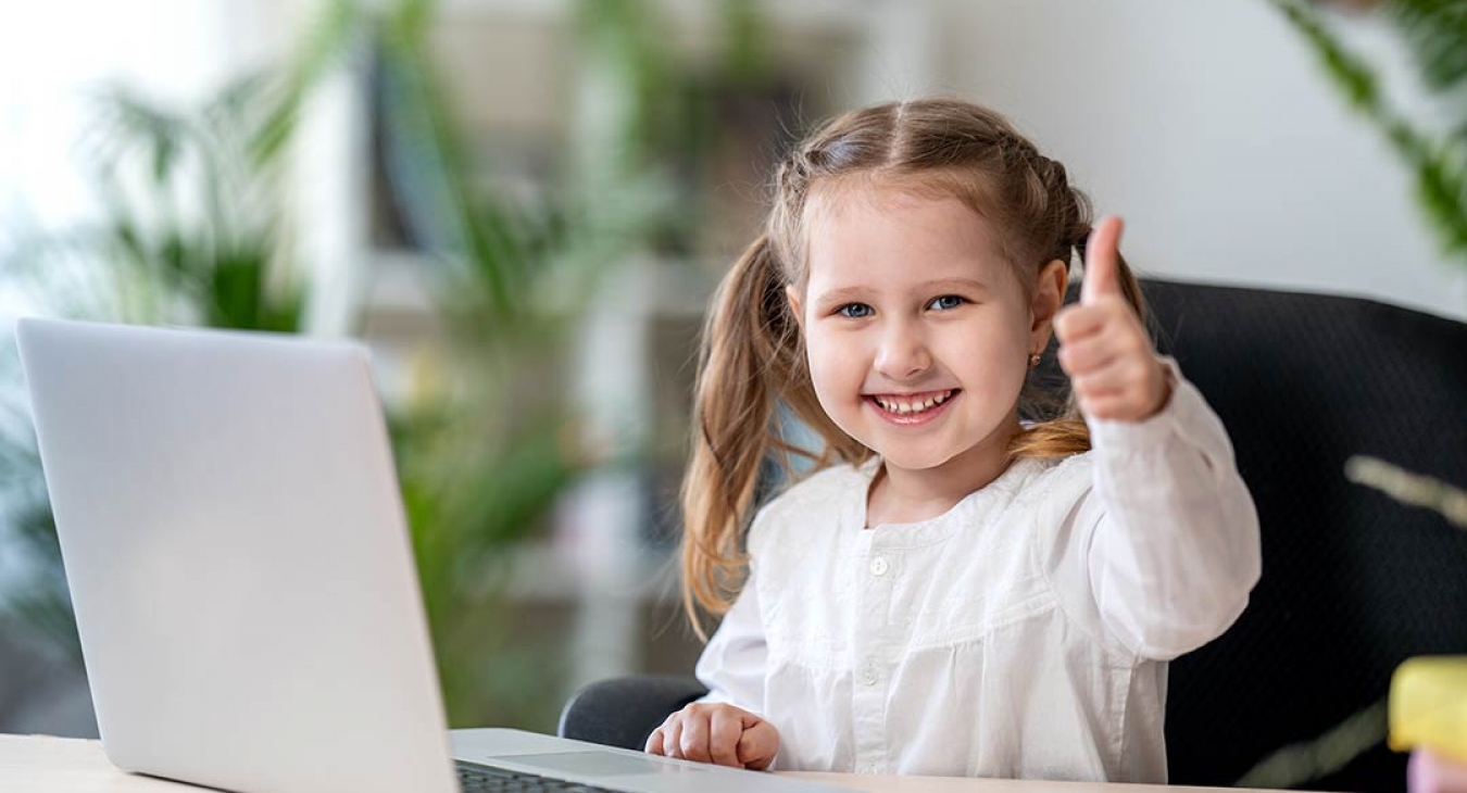 Little girl going home school work on a laptop giving thumbs up