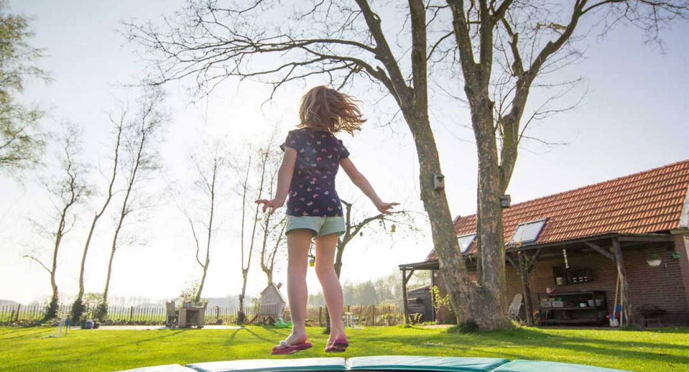 Girl exercising by jumping on a trampoline