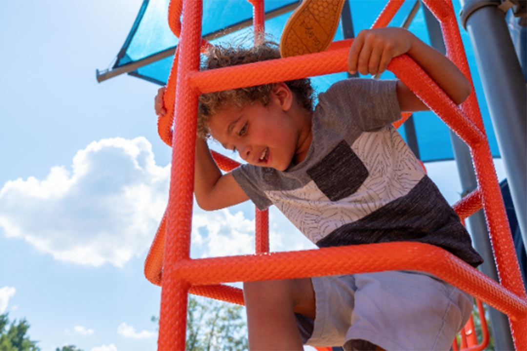 boy climbing on clean playground equipment