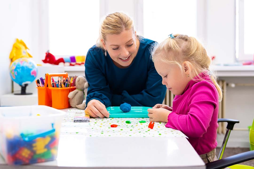 Therapist using games and play to help little blonde girl