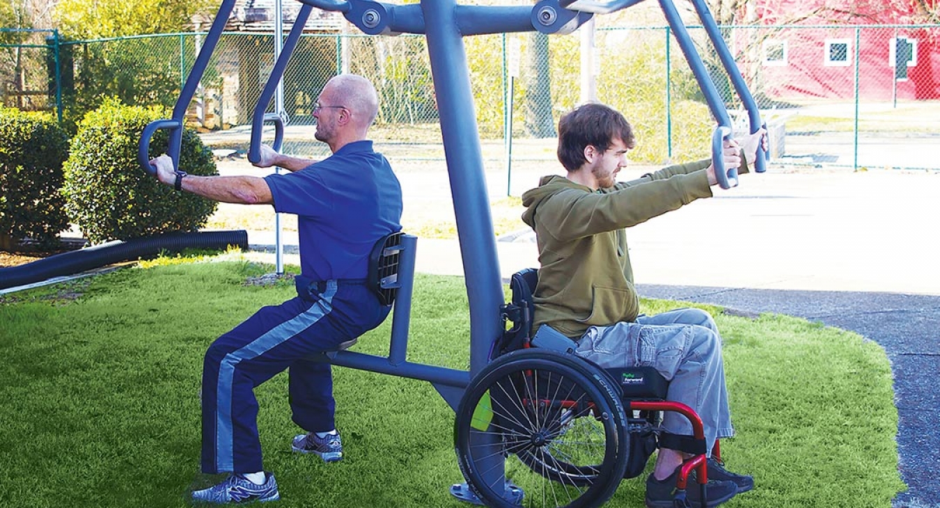 a man in a wheelchair exercising on outdoor equipment