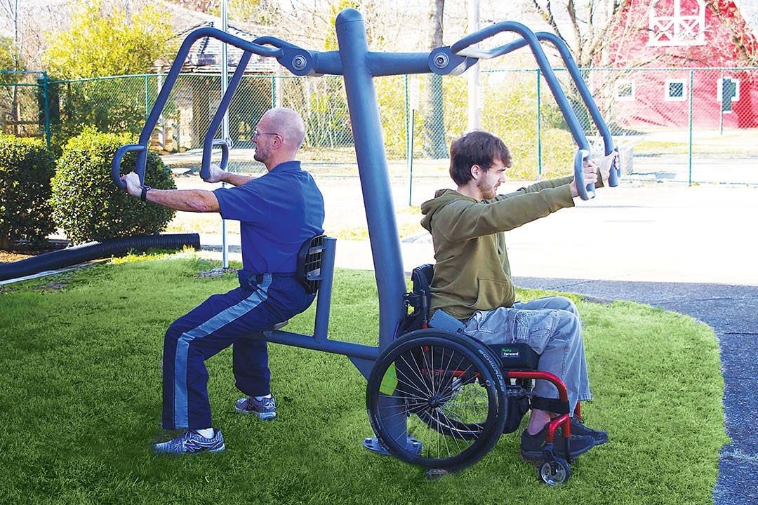 a man in a wheelchair exercising on outdoor equipment