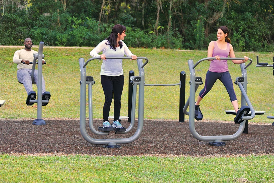 group doing leg exercises on park exercise equipment
