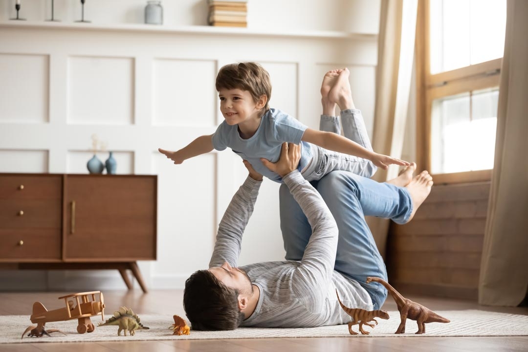 Dad playing airplane with son