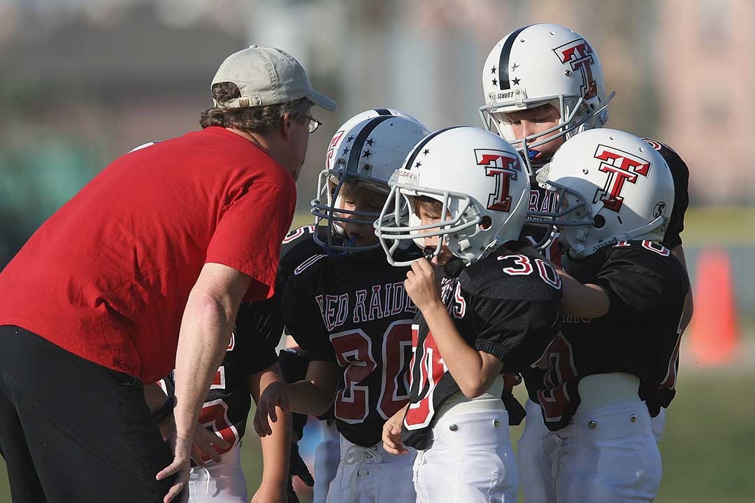coach and kids football team - all wearing mouthguards