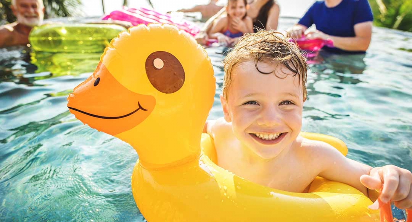 child floating in a pool on an inflatable duck