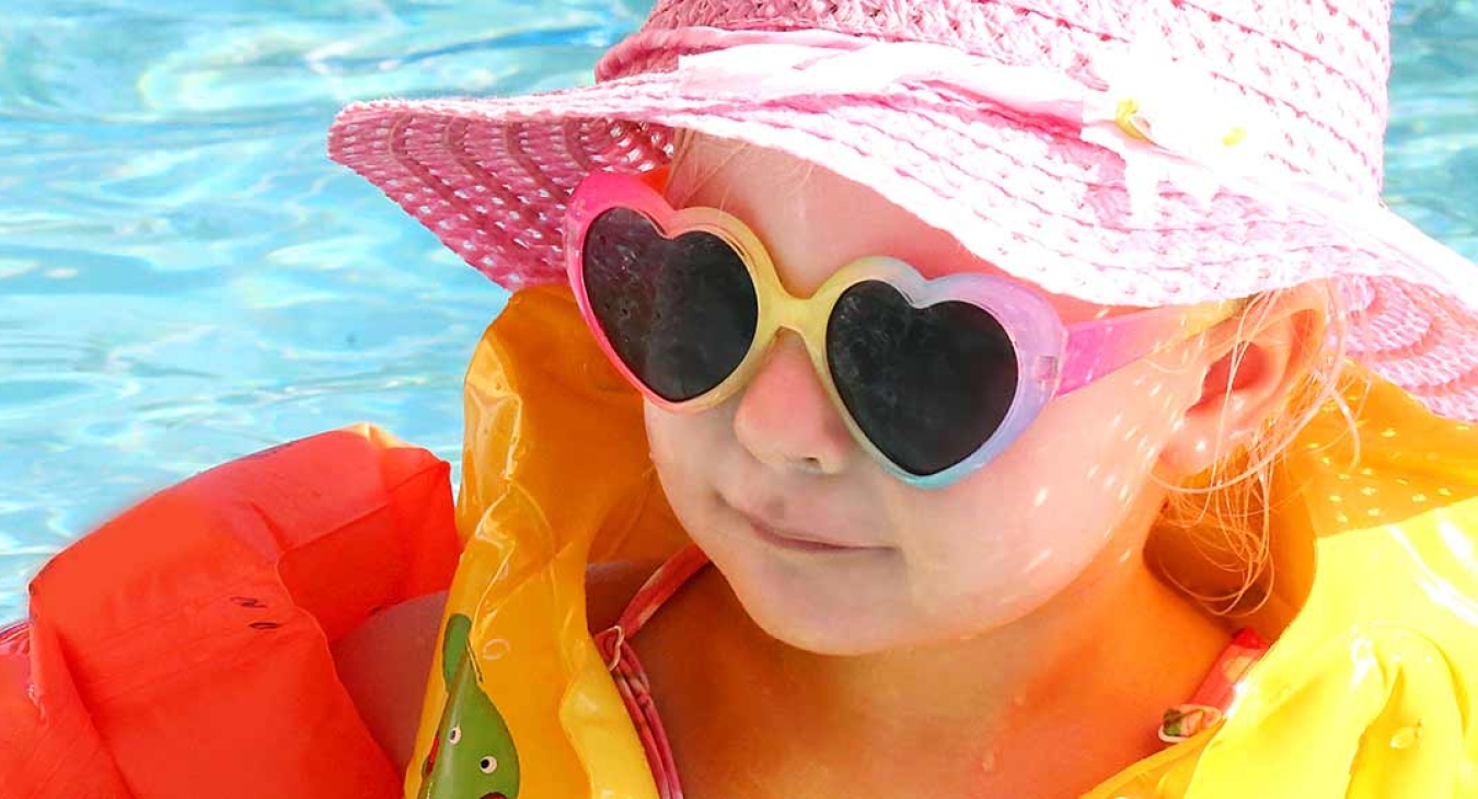 baby in pool with floaties and sun glasses