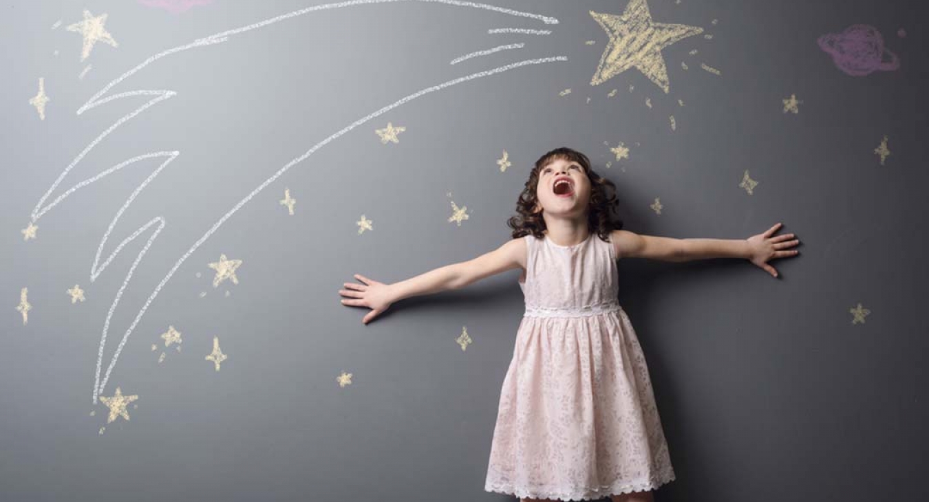 child drawing chalk on wall with star stickers