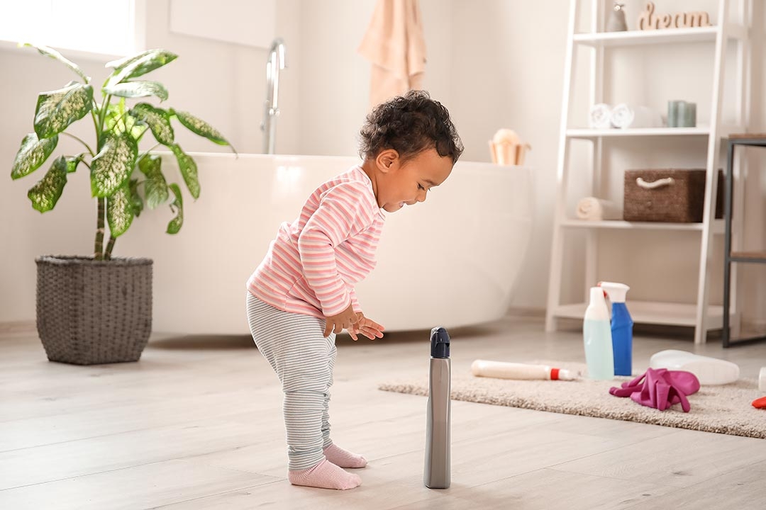 Baby playing with cleaner chemicals at home - danger
