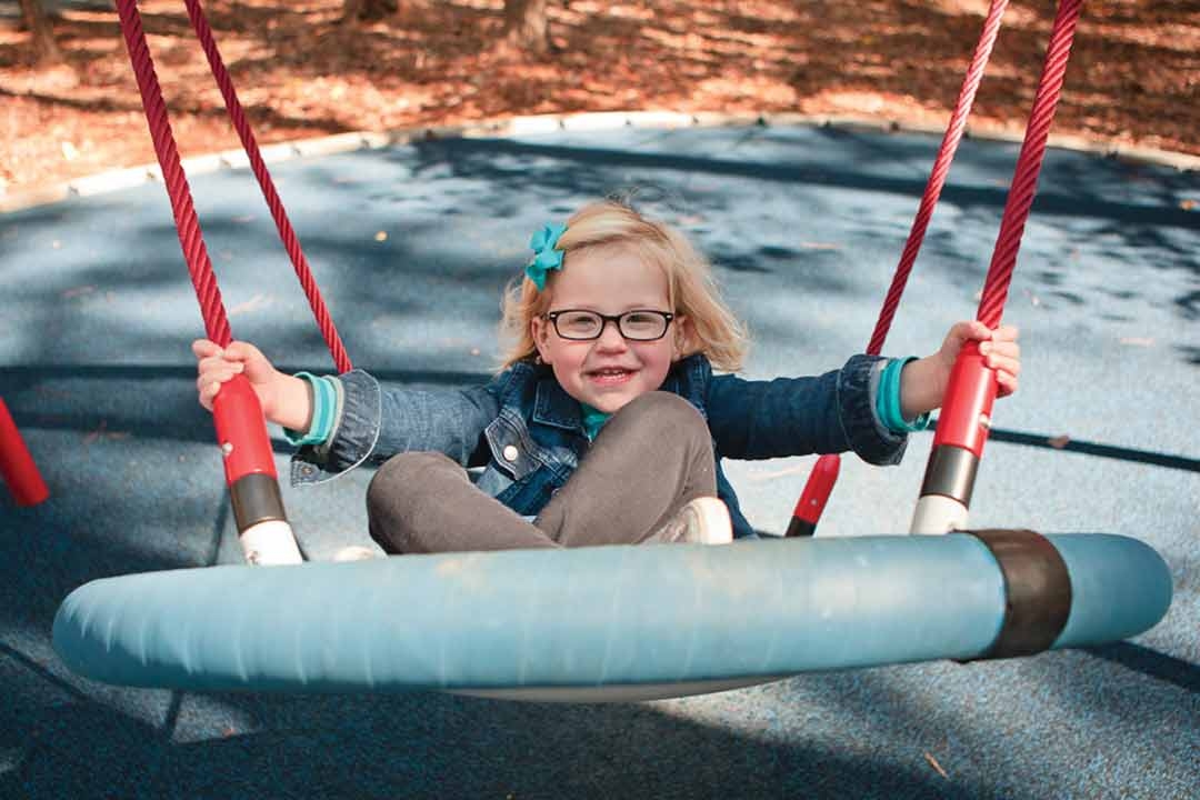 child swinging on swing set