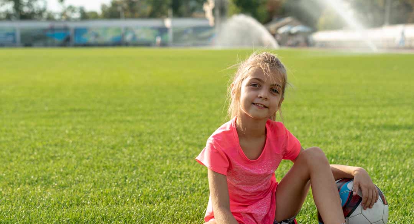 Girl in grass with a soccer ball