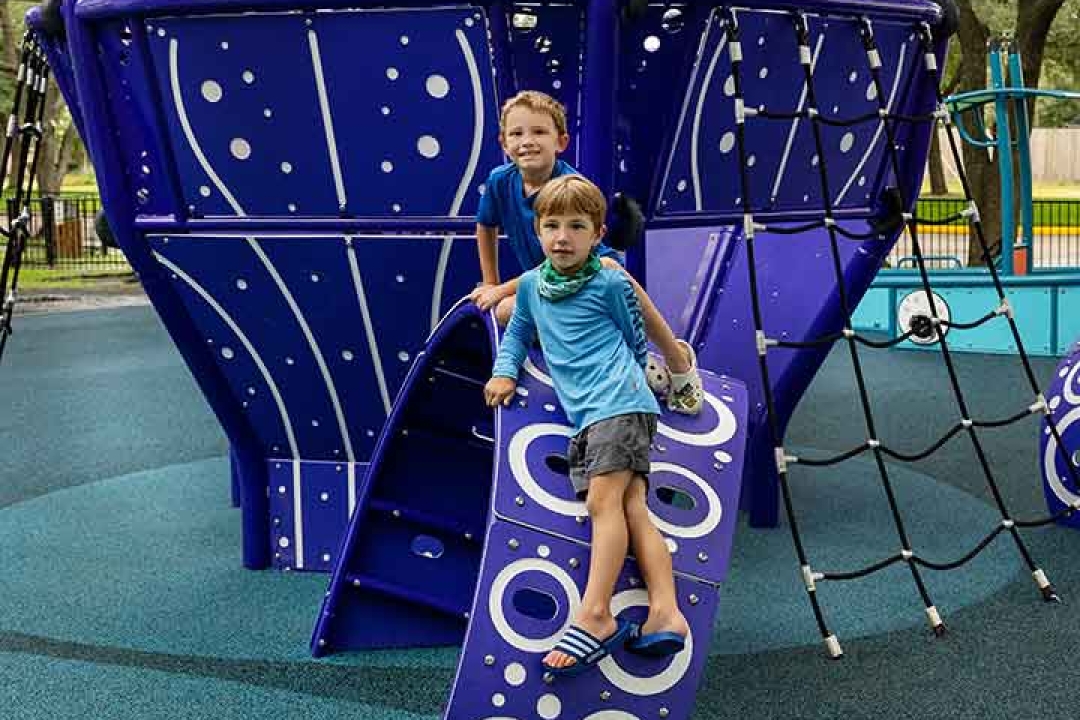 Children climbing on the GameTime kraken climber body panel with bubble-themed surfacing elements at Carol Fox Park Jersey Village Texas