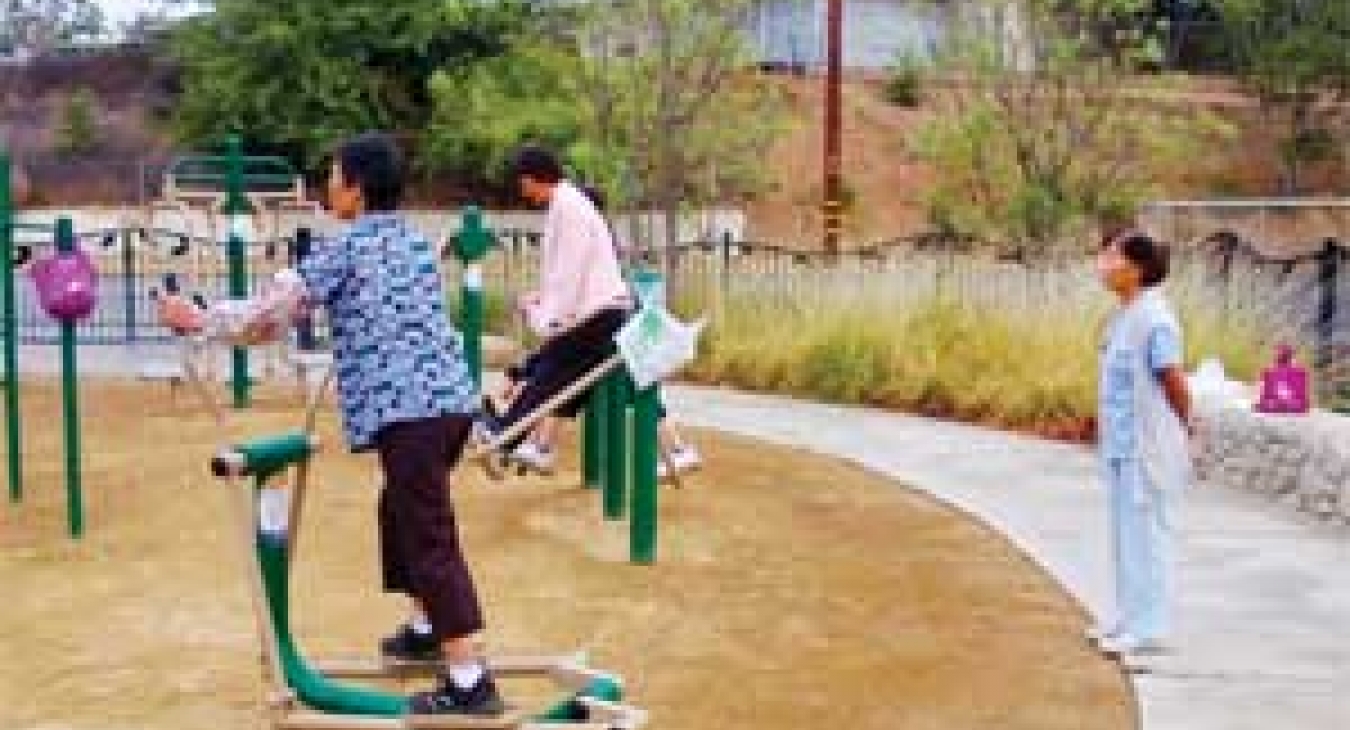 A parents gets in a workout at El Sereno Arroyo while children play