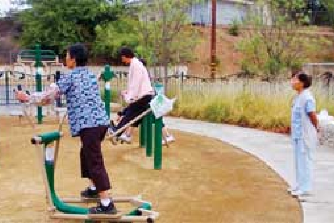 A parents gets in a workout at El Sereno Arroyo while children play