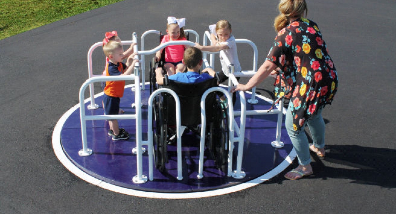 Children on a wheelchair accessible merry-go-round.