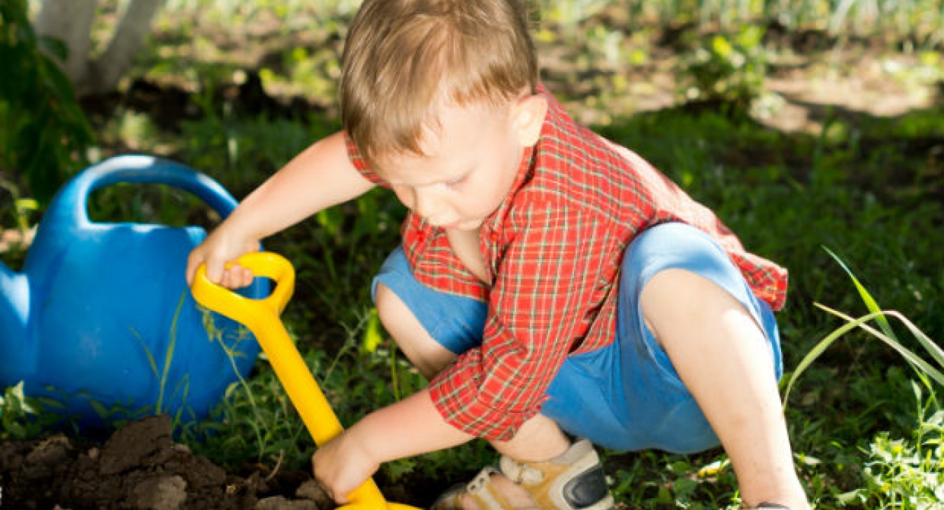 Toddler digging in the dirt.