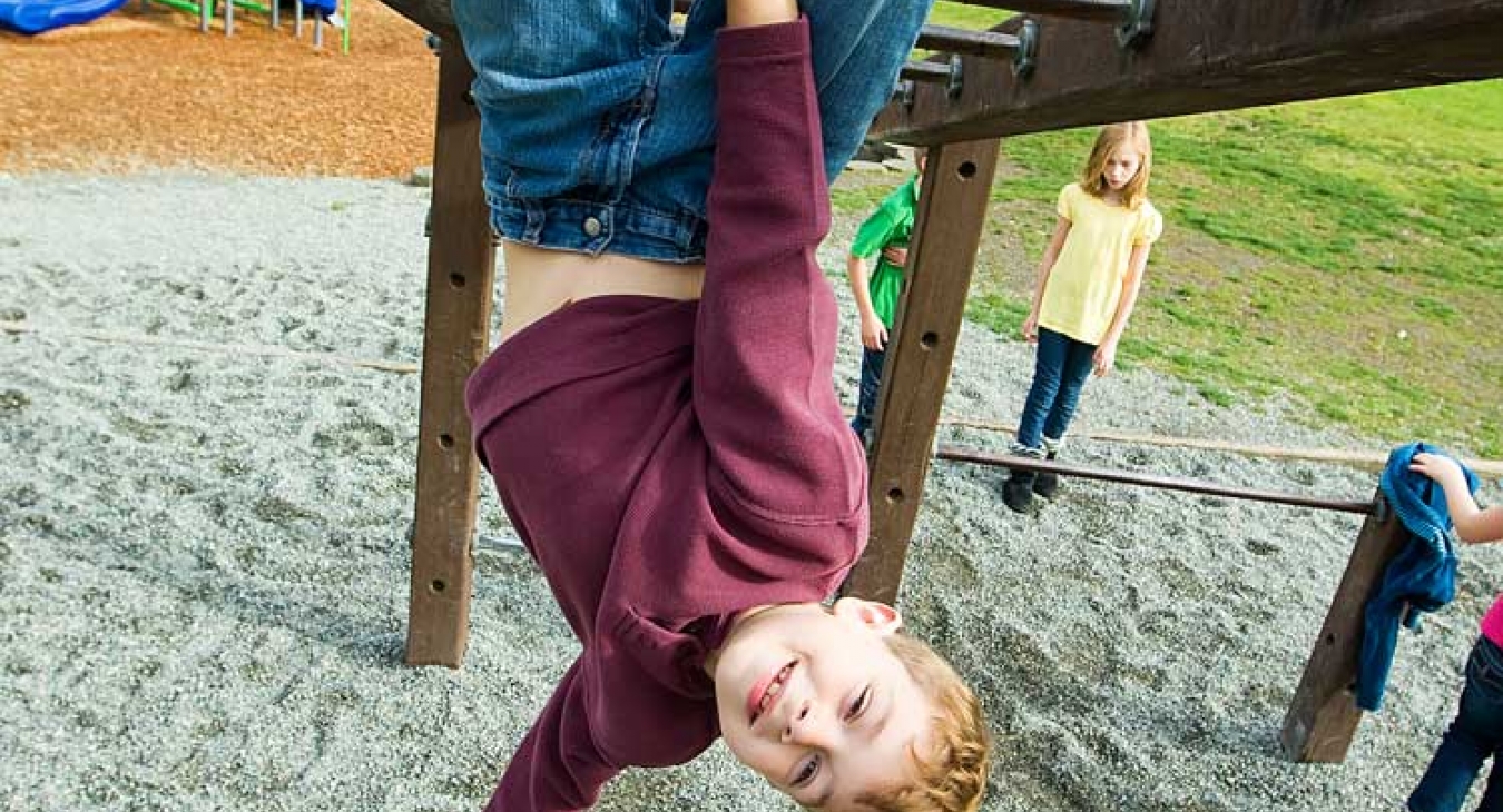 Child hanging from monkey bars.