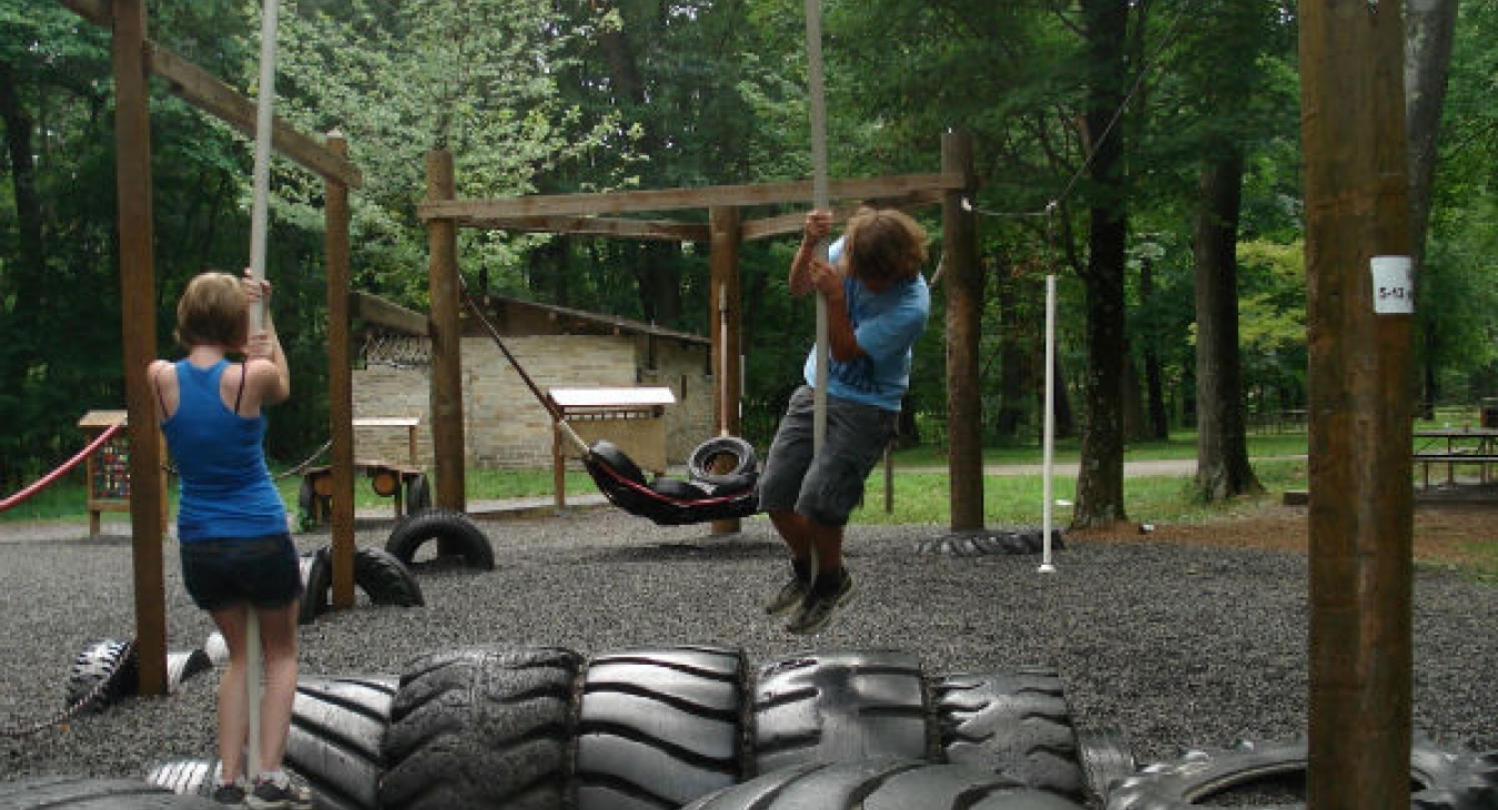 Teens playing on a playground made from old tires.
