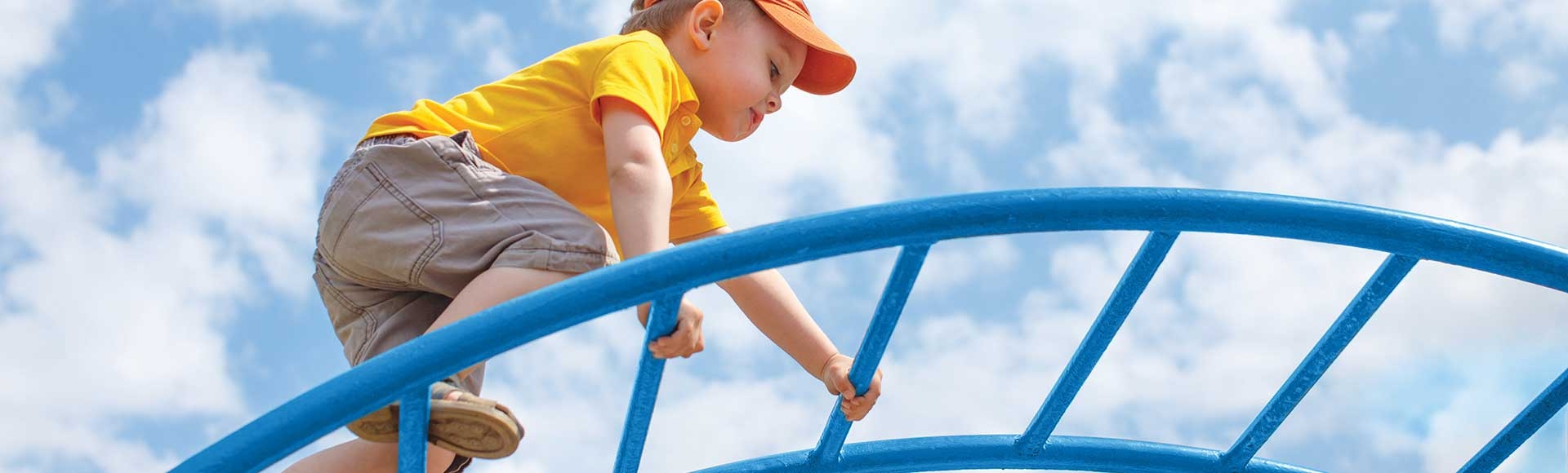 little boy climbing an arch climber playground