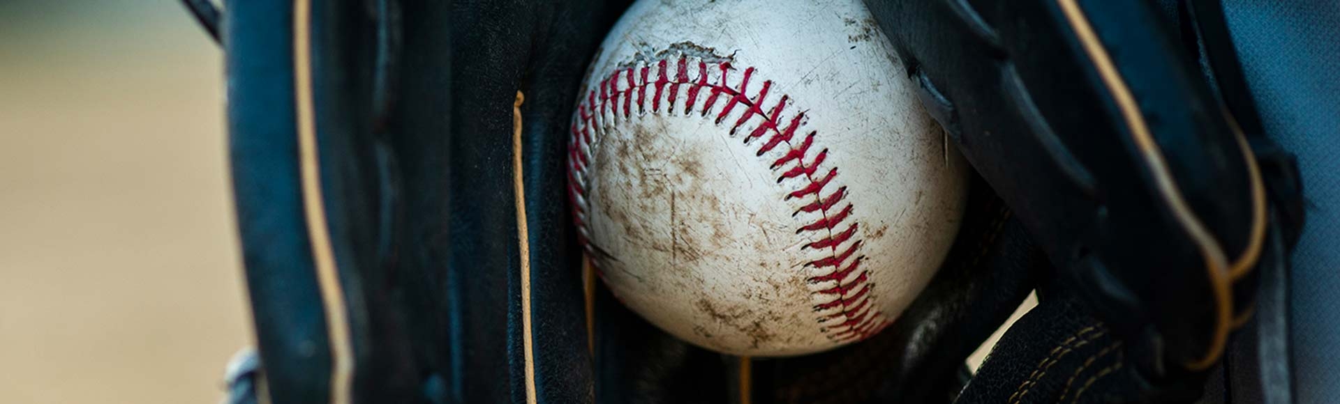close up of baseball held in glove