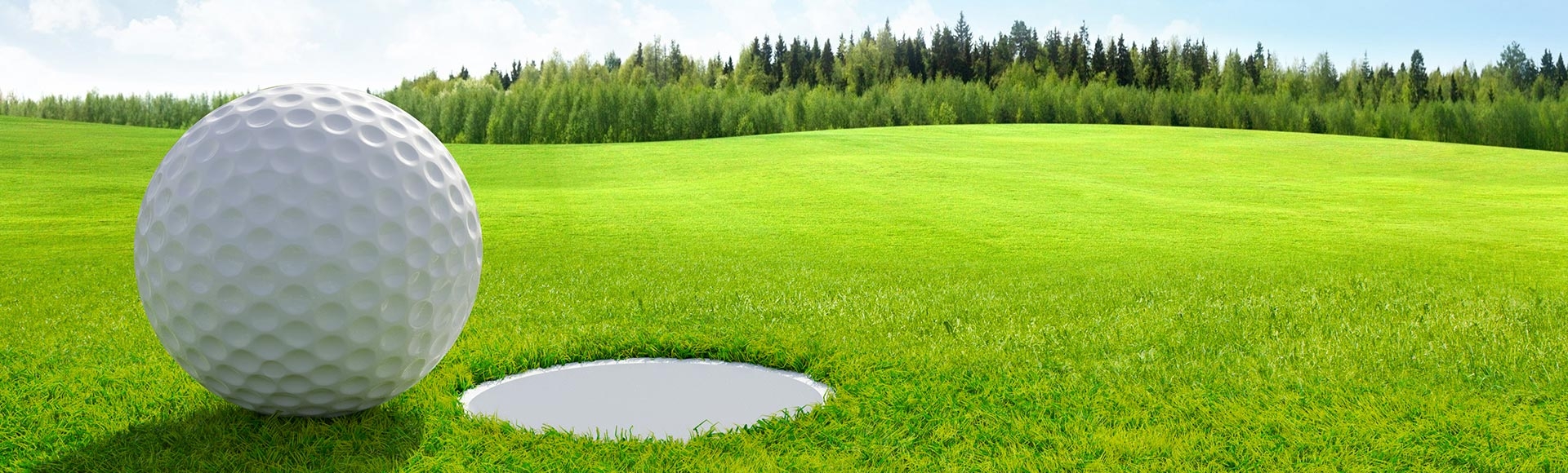 Golf ball on green about to fall in hole