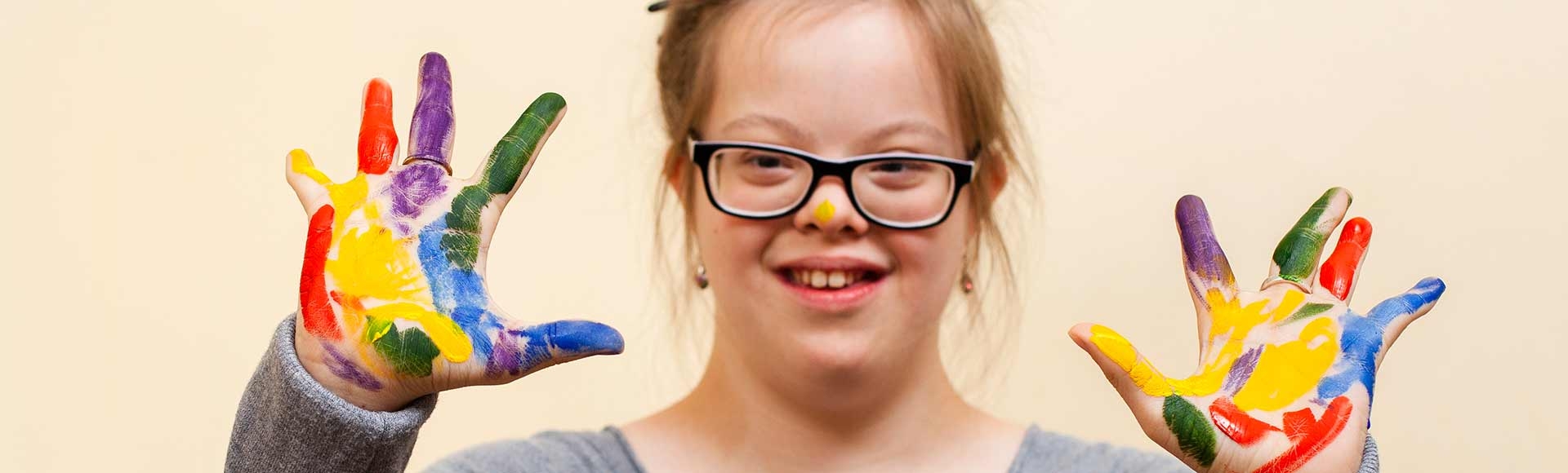 girl with down syndrome showing off her colorful palms