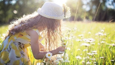 young girl playing in field of grass