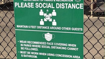 sign recommending social distancing and mask wearing