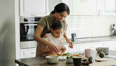 Mother and daughter preparing avocado toast