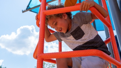 boy climbing on clean playground equipment