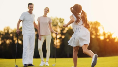 Happy family golfing during a beautiful evening