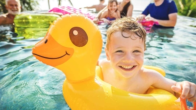 child floating in a pool on an inflatable duck
