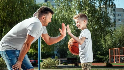 Father and son playing basketball together outdoor basketball court