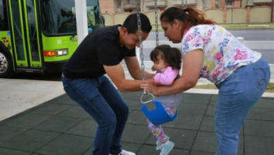 Parents and a child use the Metro McAllen “Swing and Rode” bus stop. 