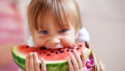Young girl eating fruit at watermelon