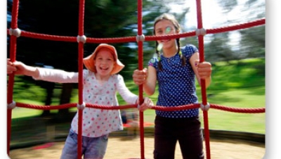 Two girls on a rotating climber in motion.