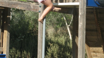 Young girl showing her power climbing a pole.